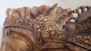 Detailed carving on king's crown of wooden sculpture