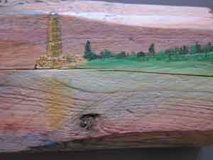 Painting of lighthouse and reflection on wood